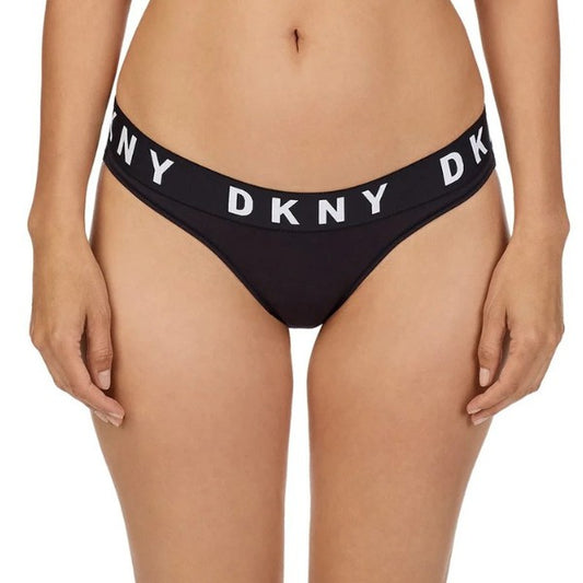 A person is shown mid-torso to upper thighs wearing DKNY Cozy Boyfriend trusser med komfortabel pasform og tyk elastisk linning med hvide "DKNY"-bogstaver på en ensfarvet, lys baggrund.