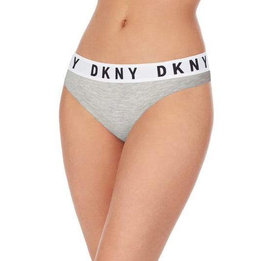 En kvinde viser DKNY Cozy Boyfriend Thong – grå bikinitrusser med en tyk hvid linning og et markant DKNY-logo – der tilbyder komfort og stil med et sporty, moderne præg mod en almindelig hvid baggrund.