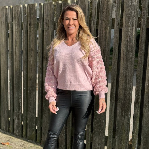 Blød sweater med plys-ærmer. Paillet detaljer på ærmerne. V-udskæring og brede ribkanter på ærmer og i bunden.