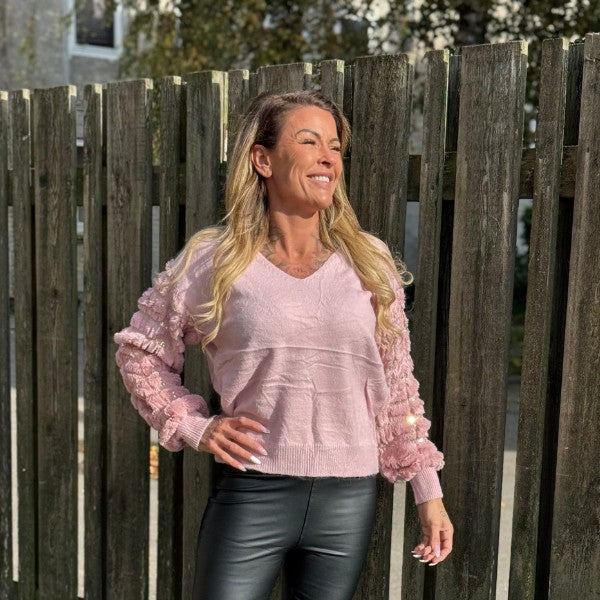 Sweater med plys-ærmer og guldfarvede paillet detaljer rundt om ærmerne.