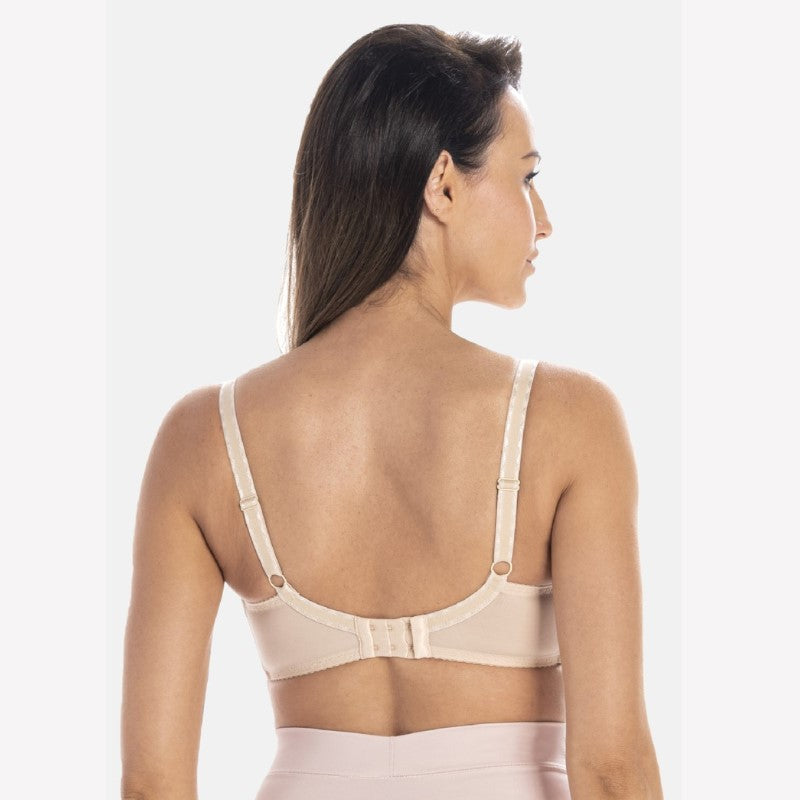 En kvinde med langt brunt hår ses bagfra iført en beige Teyli-vatteret bh med justerbare stropper, hægtelukning og fuld rygdækning på en lysegrå baggrund.