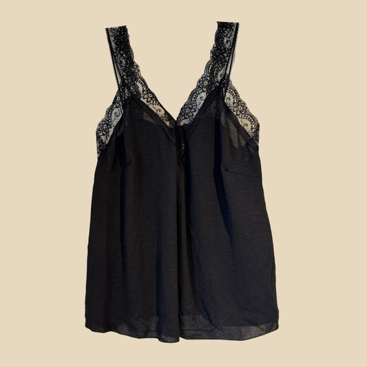 En sort stilettop fra Promise har gennembrudte blonder langs den dybe V-udskæring og skulderstropperne. På en almindelig beige baggrund giver det lette, lidt gennemsigtige stof et elegant, feminint touch.