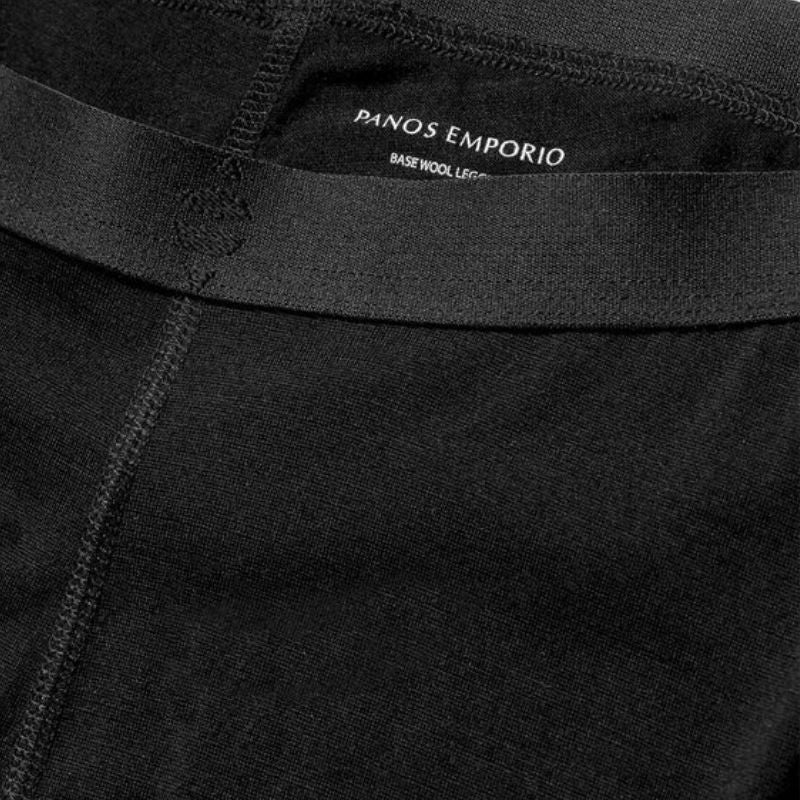 Nærbillede af sorte Panos Emporio-leggings i merinould med synlige syninger, elastisk linning og indvendig label med teksten PANOS EMPORIO BASE WOOL LEG. Billedet fremhæver det strukturerede stof og sømdetaljerne.