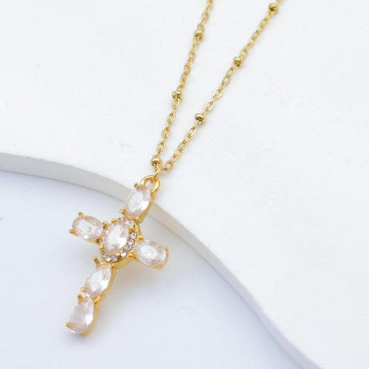 Guldfarvet halskæde med et korsformet vedhæng dekoreret med klare sten.