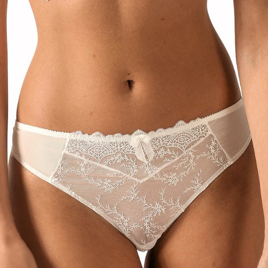 Et nærbillede af en kvinde iført Empreinte Louise g-streng i gennemsigtig hvid blonde med blomsterbroderi, en delikat sløjfe, skulpterede kanter, delvist gennemsigtige sidepaneler og en behagelig pasform for ultimativ komfort.