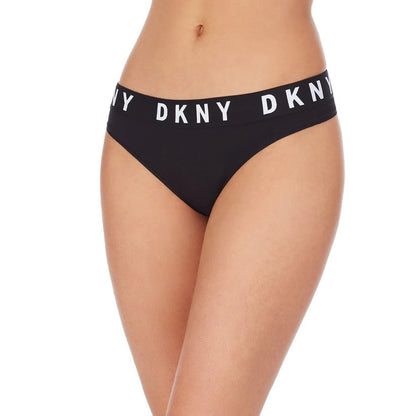 En person modellerer sort DKNY Cozy Boyfriend Thong bikinitrusse i bikinistil med en bred linning med hvidt logo, vist fra torso til overlår mod en almindelig hvid baggrund for et sporty look.