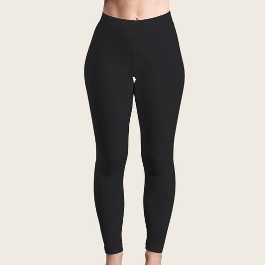 En person står model til E Avantgarde Black Long Leggings på en lys beige baggrund, hvor kun overkroppen og benene er synlige. De sømløse, tætsiddende leggings understreger deres moderne design.