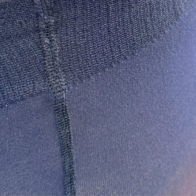 Nærbillede af mørkeblåt, struktureret mikrofiber 3D-materiale fra Festival Strømper med synlige syninger og ribkant i taljen. Strækbart stof giver komfort, ideelt til strømpebukser eller aktivt tøj.