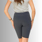 Bagpå modellen, grå korte leggings, med bred talje. De korte leggings går midt på låret. 