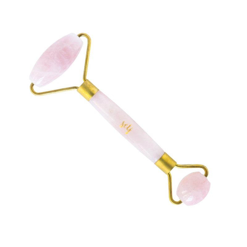Natural Self Rose Quartz Facial Roller har guldbeslag og to lyserøde stenender til ansigtsmassage, der hjælper med at reducere hævelser. Håndtaget er udsmykket med elegante guldbogstaver med "sey", hvilket giver et luksuriøst præg.