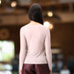 Bagfra kan man se den langærmet beige cashmere trøje.