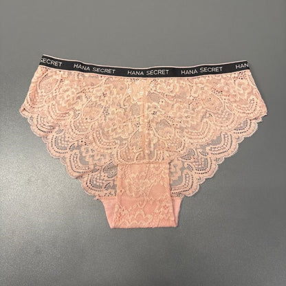 Et par lyserøde JESSYLIA Lace-trusser med skulpterede kanter vises på en grå overflade. Den sorte linning har gentagende hvid HANA SECRET-tekst, og de blomstrede blonder giver et feminint touch til disse rosa trusser.