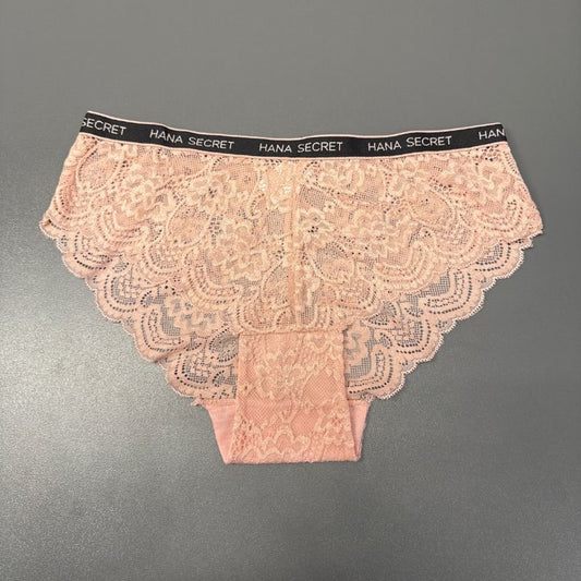 Et par lyserøde JESSYLIA Lace-trusser med skulpterede kanter vises på en grå overflade. Den sorte linning har gentagende hvid HANA SECRET-tekst, og de blomstrede blonder giver et feminint touch til disse rosa trusser.
