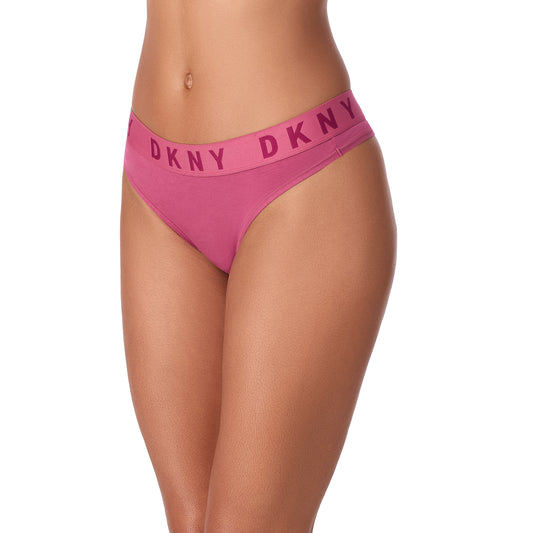 En model er iført lilla DKNY Cozy Boyfriend Thong bikiniundertøj med bred linning og kraftige mørkrosa DKNY-bogstaver, der vises fra midt på maven til midt på låret mod en almindelig hvid baggrund.