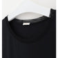 Et nærbillede af en sort Oroblu t-shirt med rund hals, der er ideel som en slags bluse, hænger på en hvid bøjle. T-shirten har en glat, almindelig tekstur med Oroblu-halsmærket synligt mod en enkel hvid baggrund.