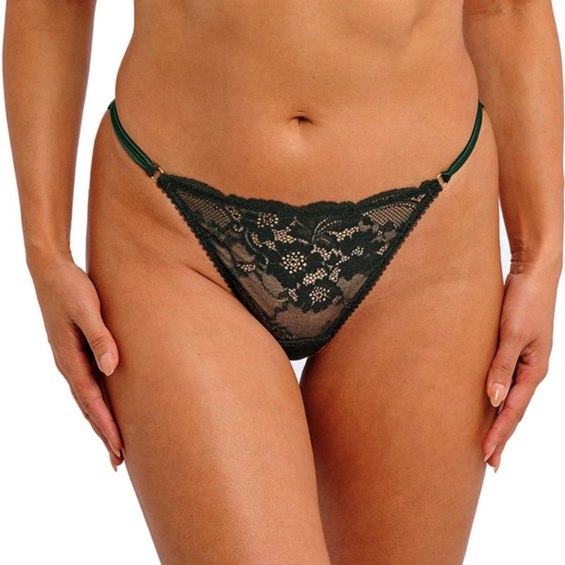 En person er iført Wacoal sort blondeundertøj i bikini-stil med tynde stropper i siden og et blomstret hulmønster. Afbildet fra midt på torsoen til øvre lår mod en ensfarvet baggrund, og hænderne hviler nær hofterne.